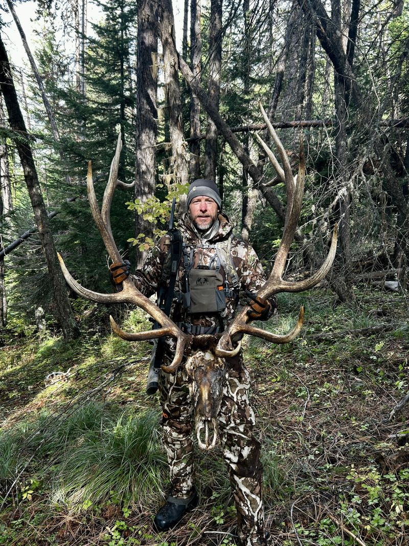 Toby in the timber holding a set of elk antlers